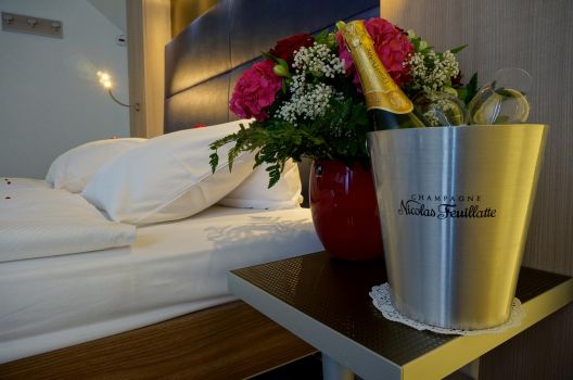 Modernes Hotelzimmer dekoriert mit Blumen und Champagner